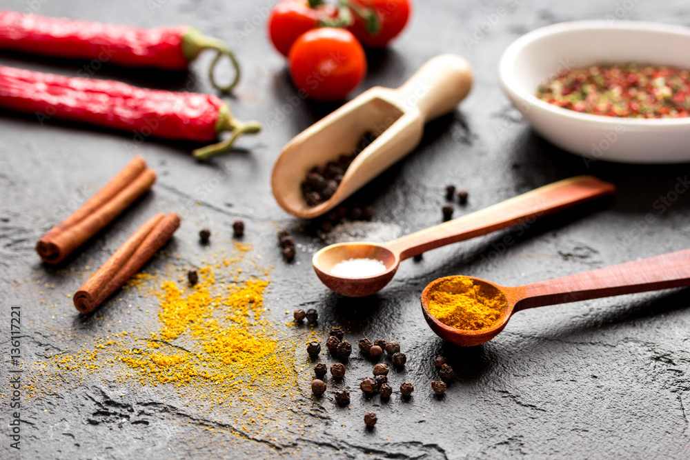 spices in wooden spoon on dark background