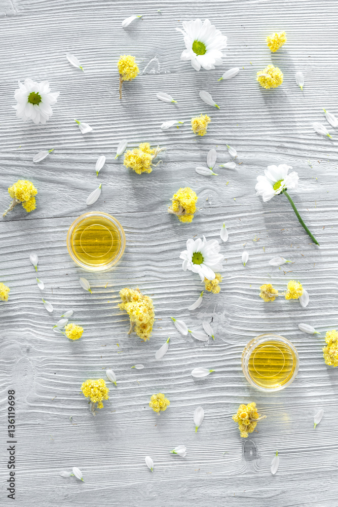 organic cosmetics with camomile on wooden background top view