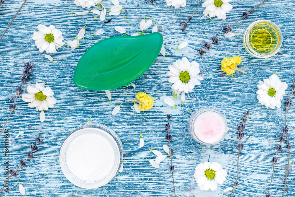 organic cosmetics with camomile on blue background top view