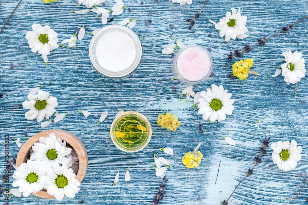 organic cosmetics with camomile on blue background top view