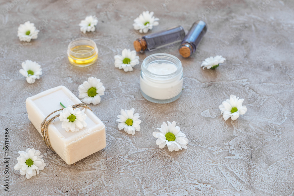 organic cosmetics with camomile on stone background