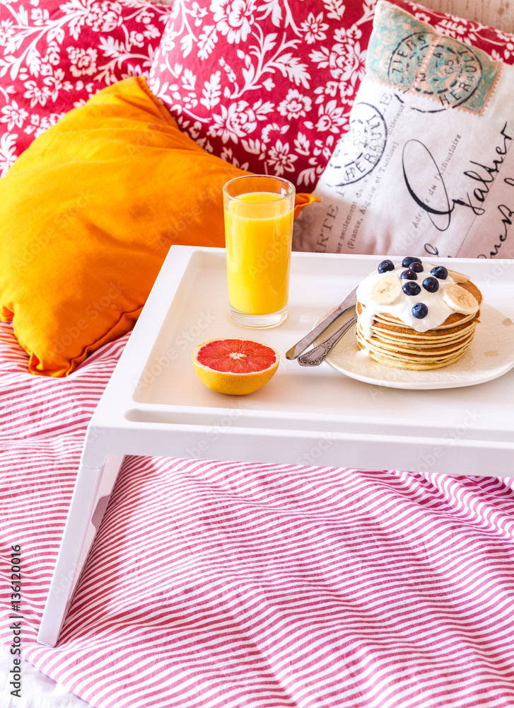 concept of breakfast in bed on tray with juice