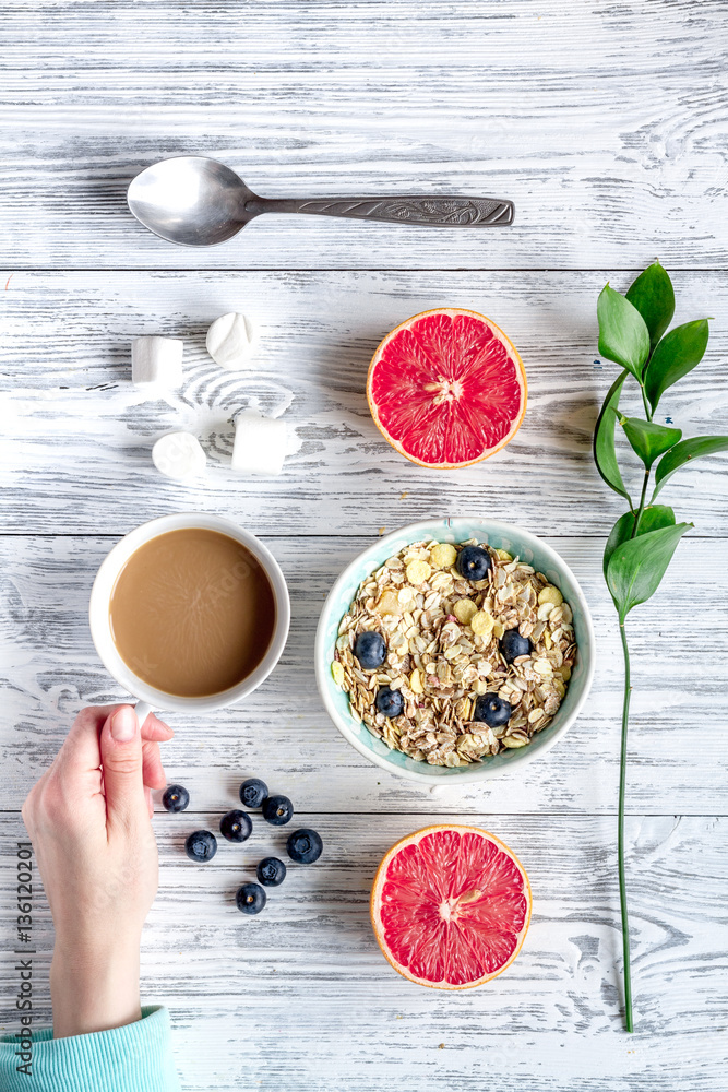 Breakfast concept with flowers on wooden background top view