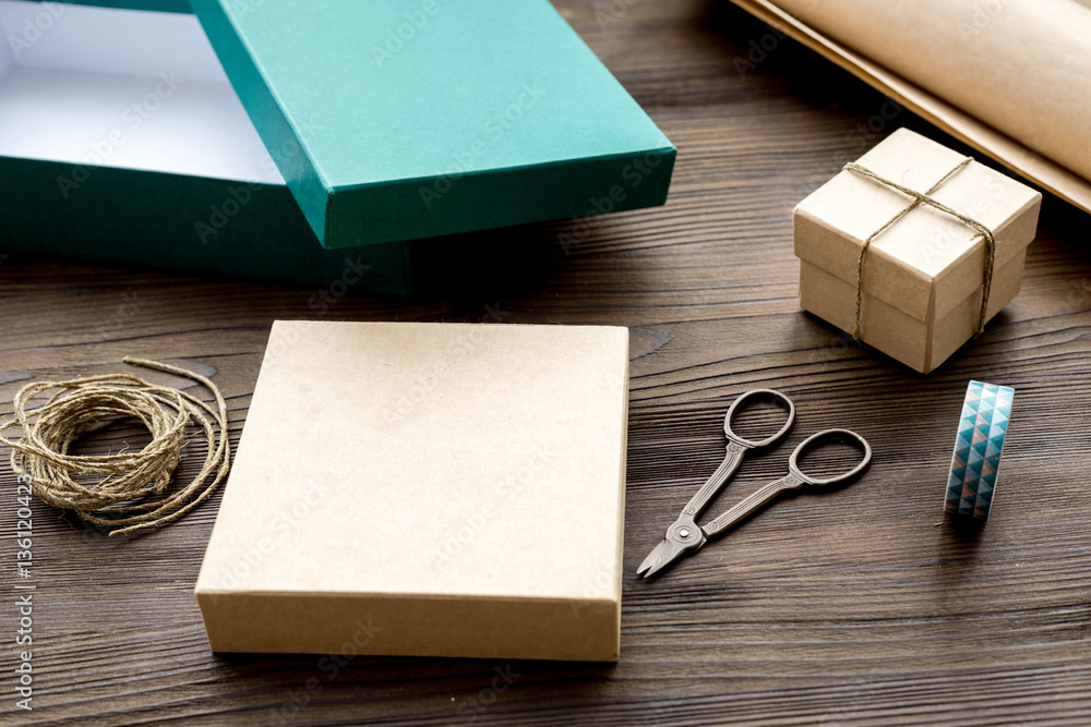 wrapping gifts in box for holiday on wooden background