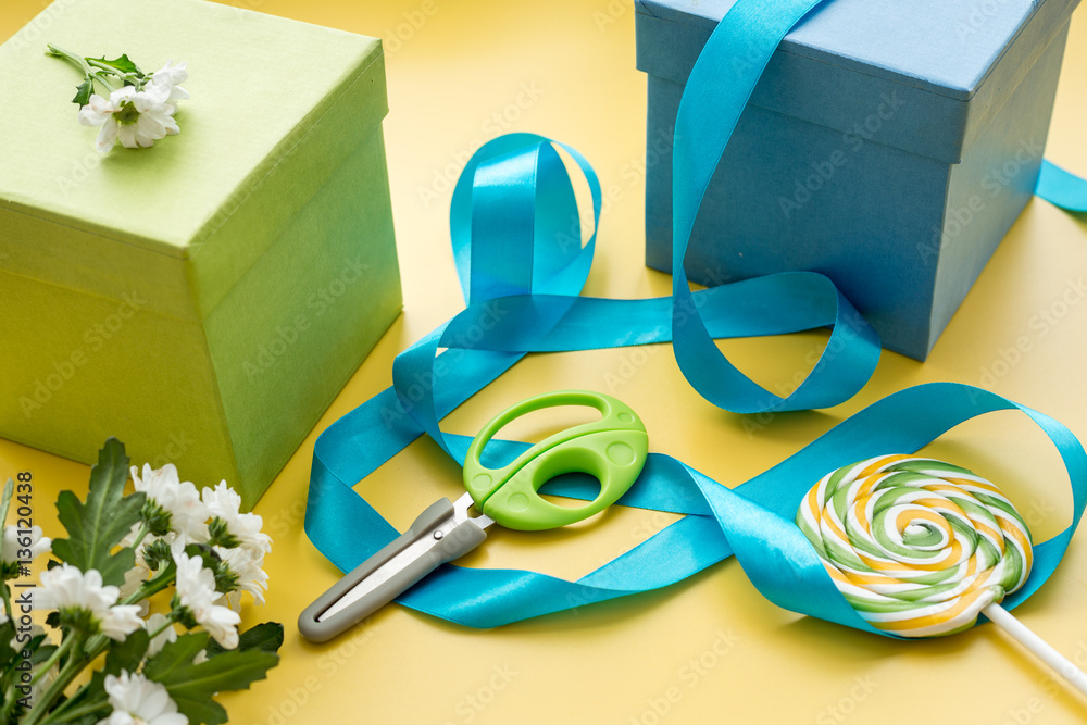 wrapping gifts in box for holiday on yellow background