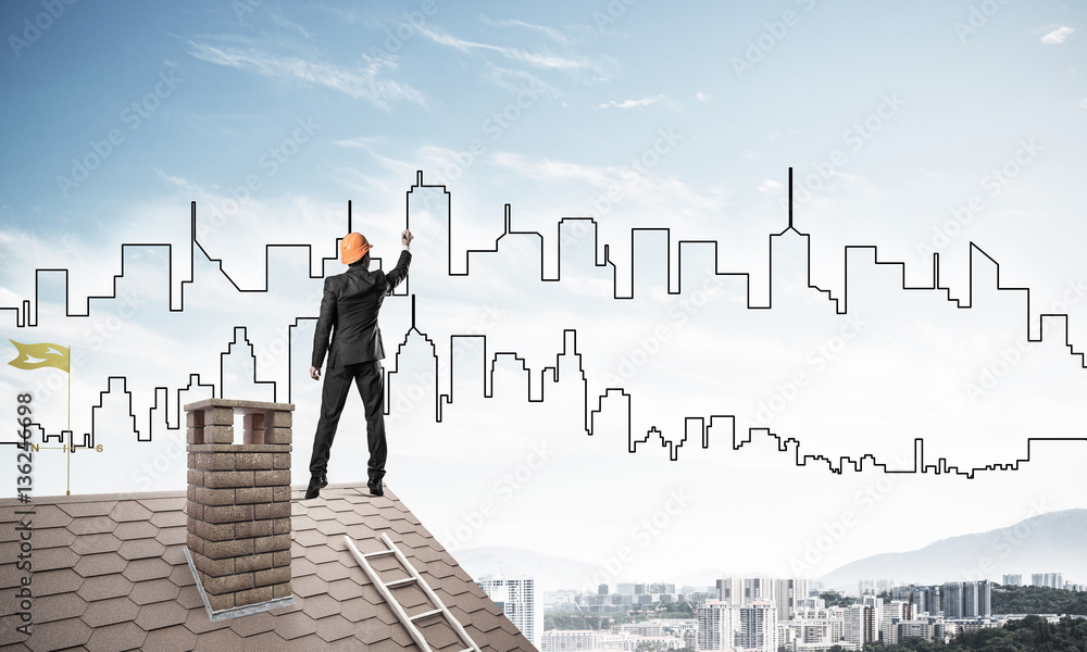 Man architect draw silhouette of modern city on blue sky. Mixed 