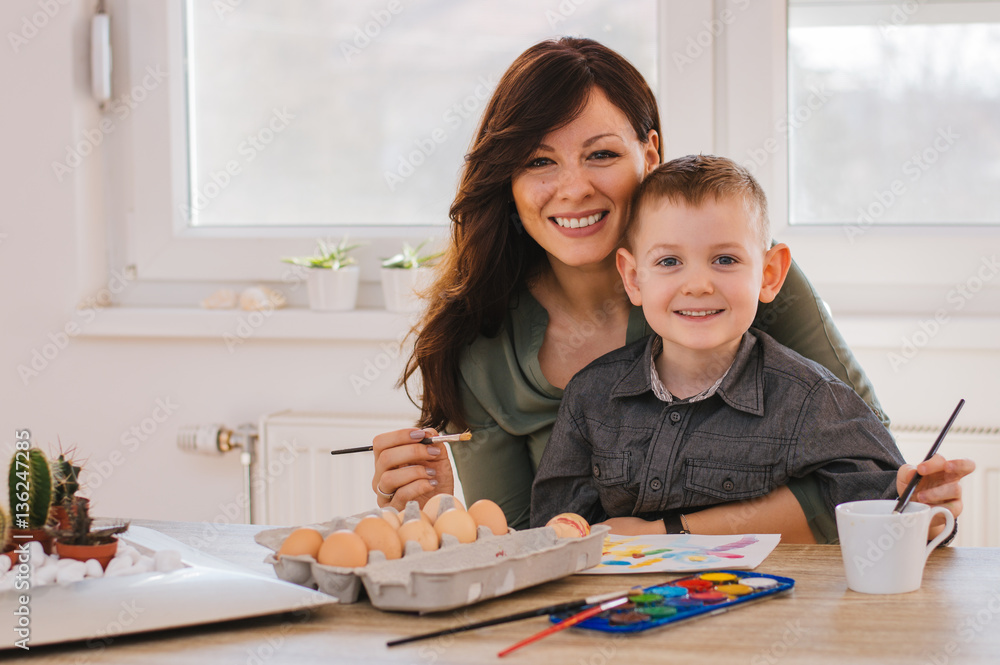 Happy family painting eggs for Easter