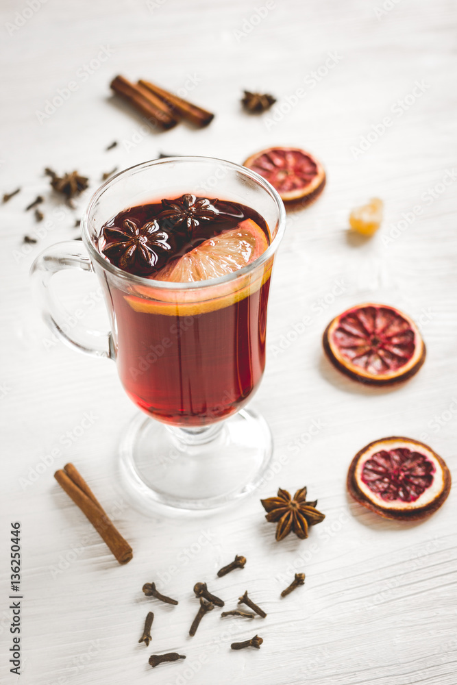 mulled wine with spices in cup on wooden background