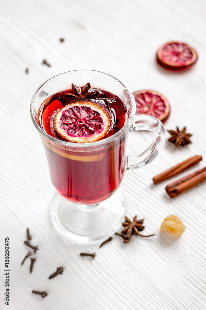 mulled wine with spices in cup on wooden background