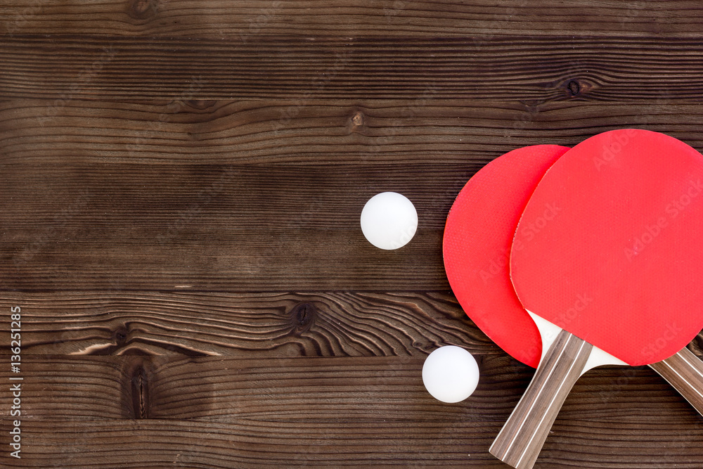 Red racket for ping pong ball wooden background top view