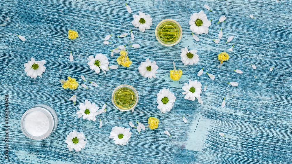 organic cosmetics with camomile on blue background top view