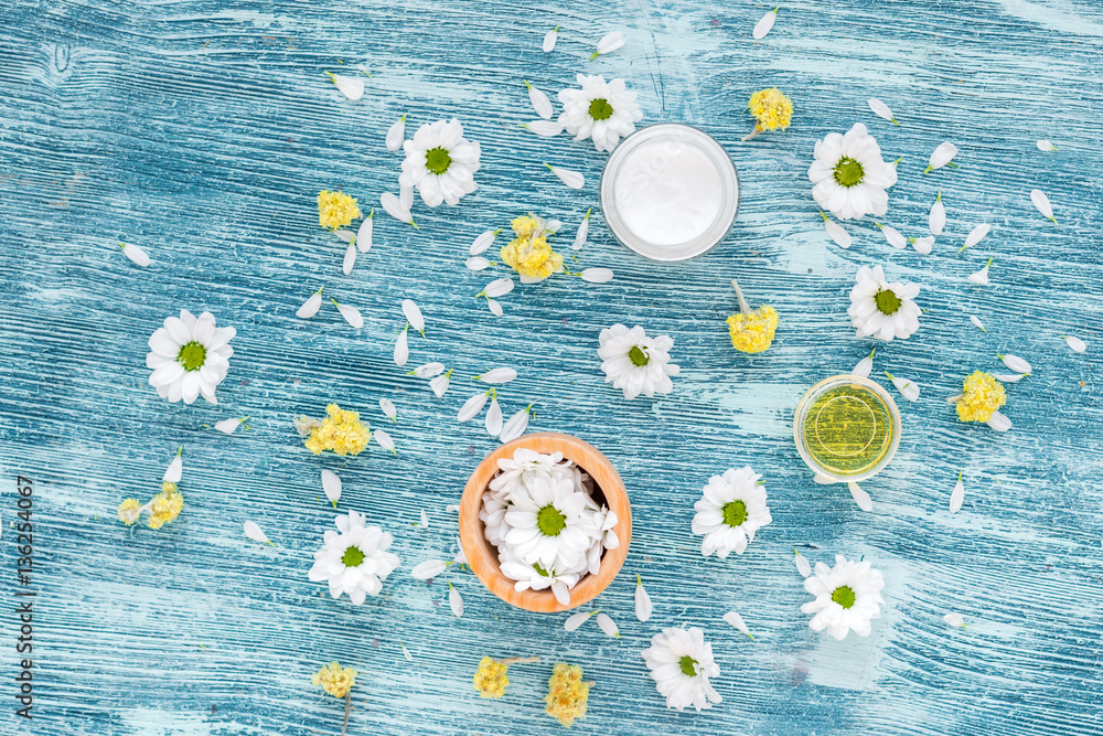 organic cosmetics with camomile on blue background top view