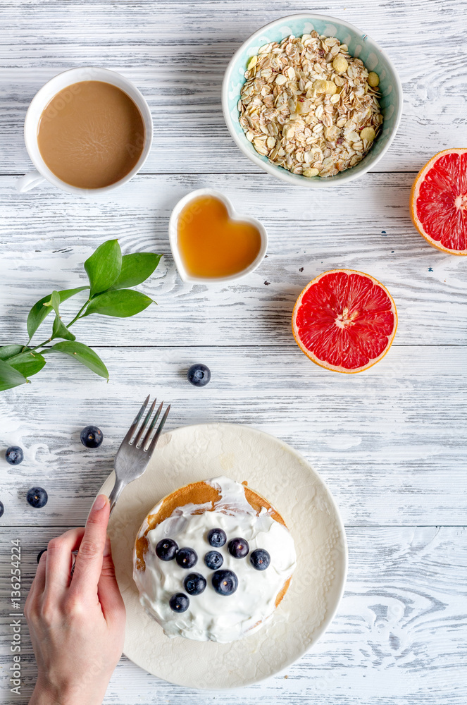 Breakfast concept with flowers on wooden background top view