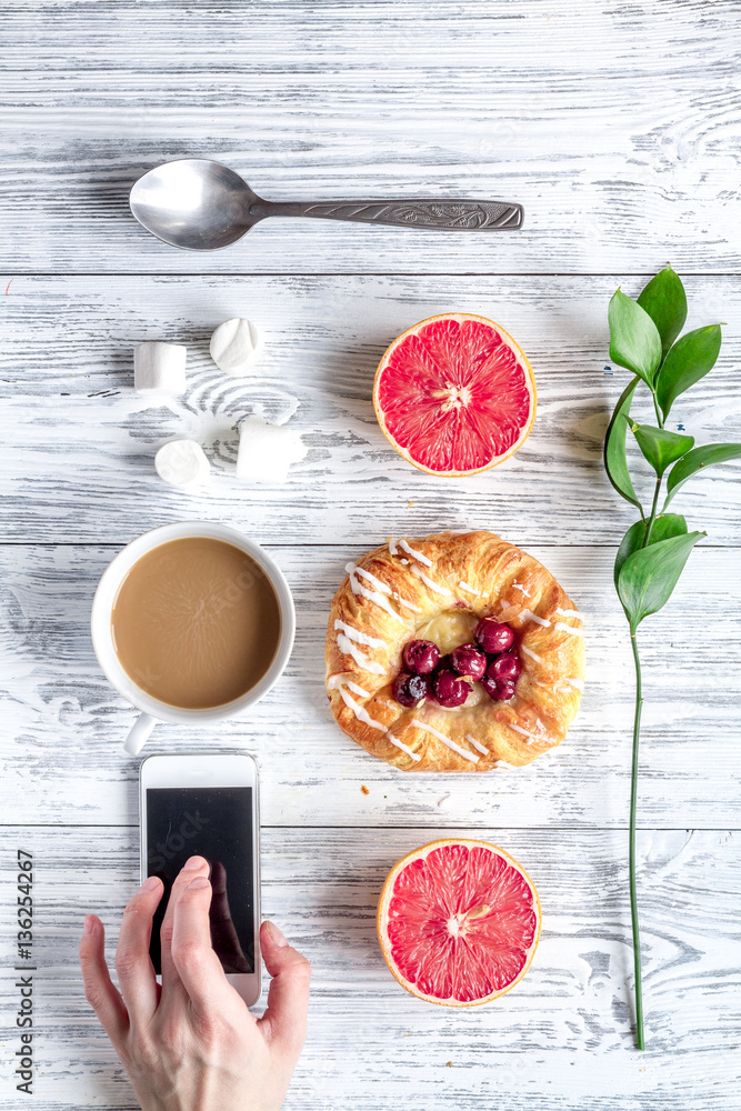 Breakfast concept with flowers on wooden background top view