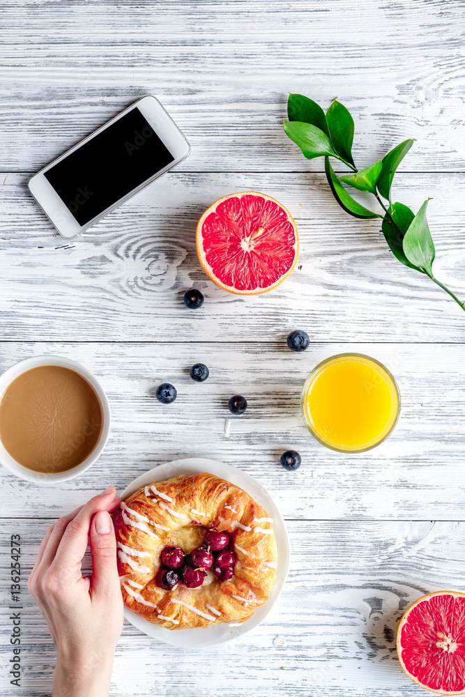 Breakfast concept with flowers on wooden background top view