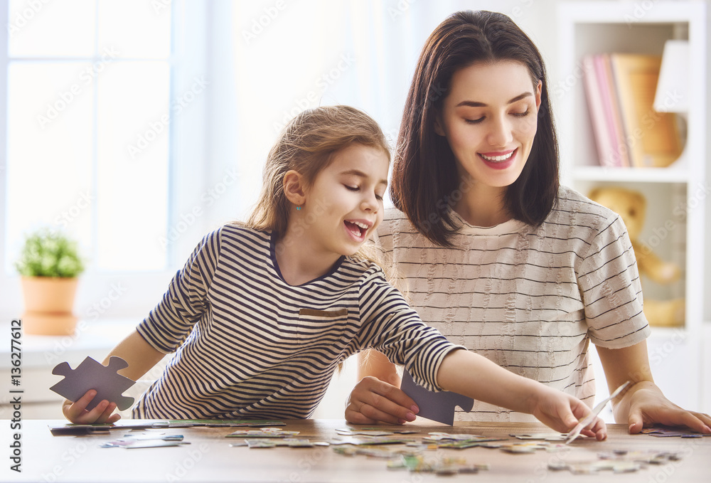 Mother and daughter do puzzles