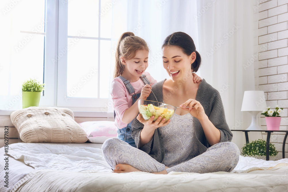 Mother and daughter eating salad