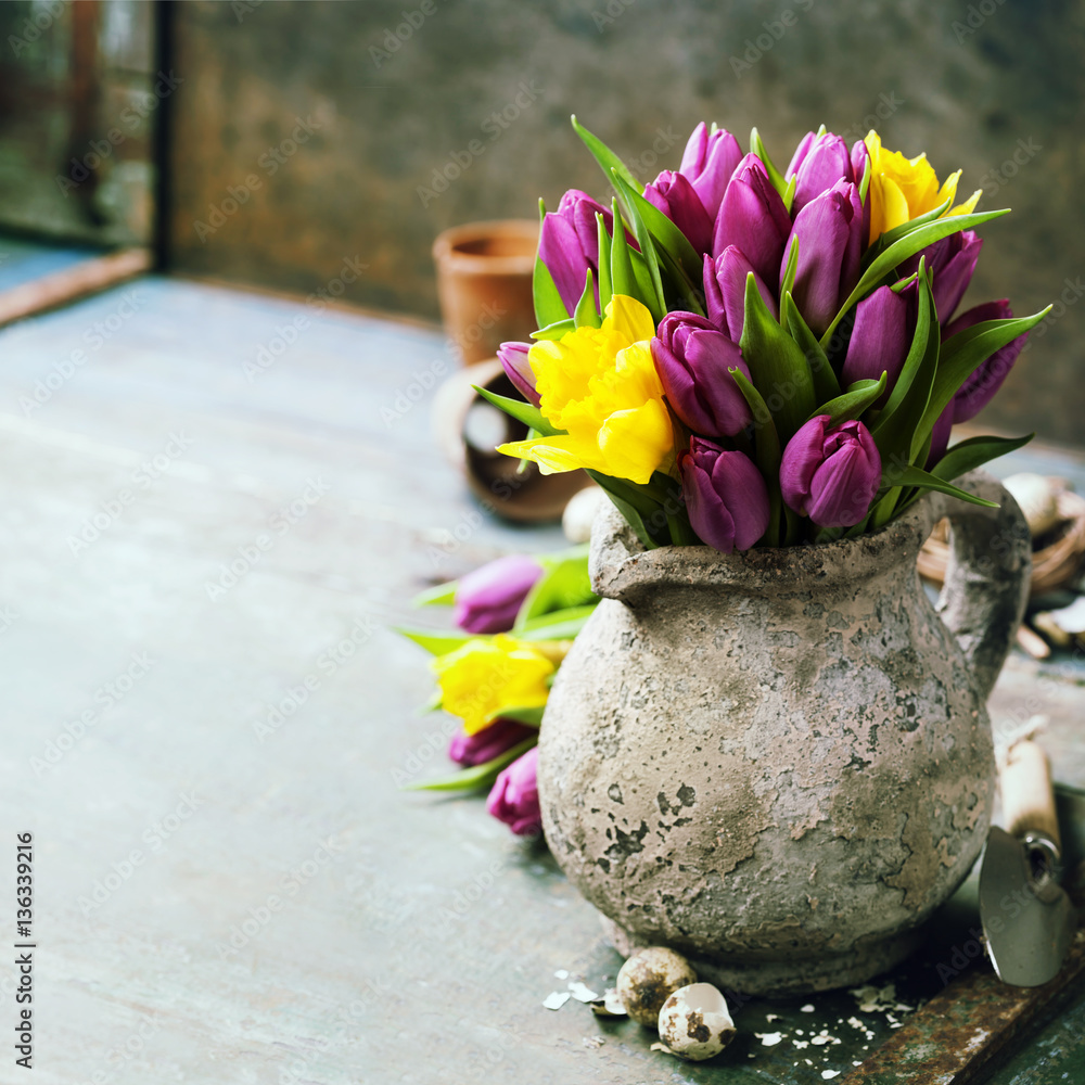 Beautiful spring tulips bouquet, easter eggs and garden tools