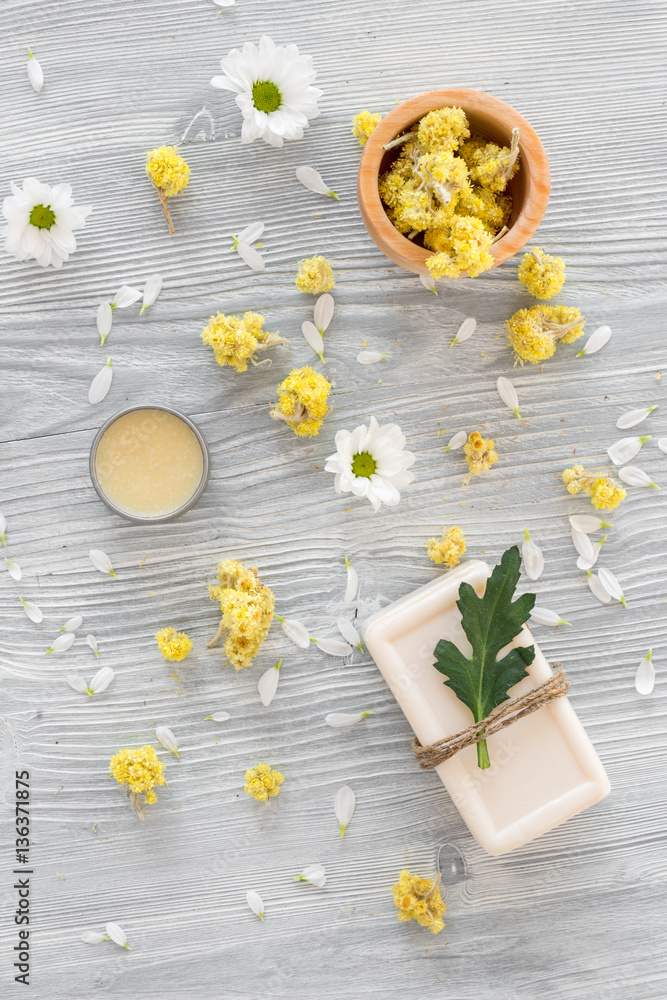 organic cosmetics with camomile on wooden background top view