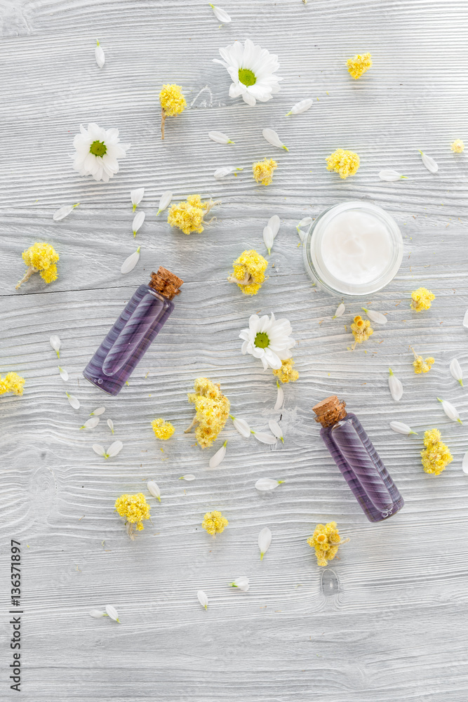 organic cosmetics with camomile on wooden background top view