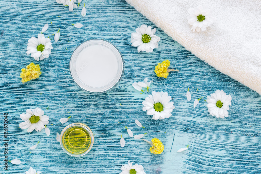 organic cosmetics with camomile on blue background top view