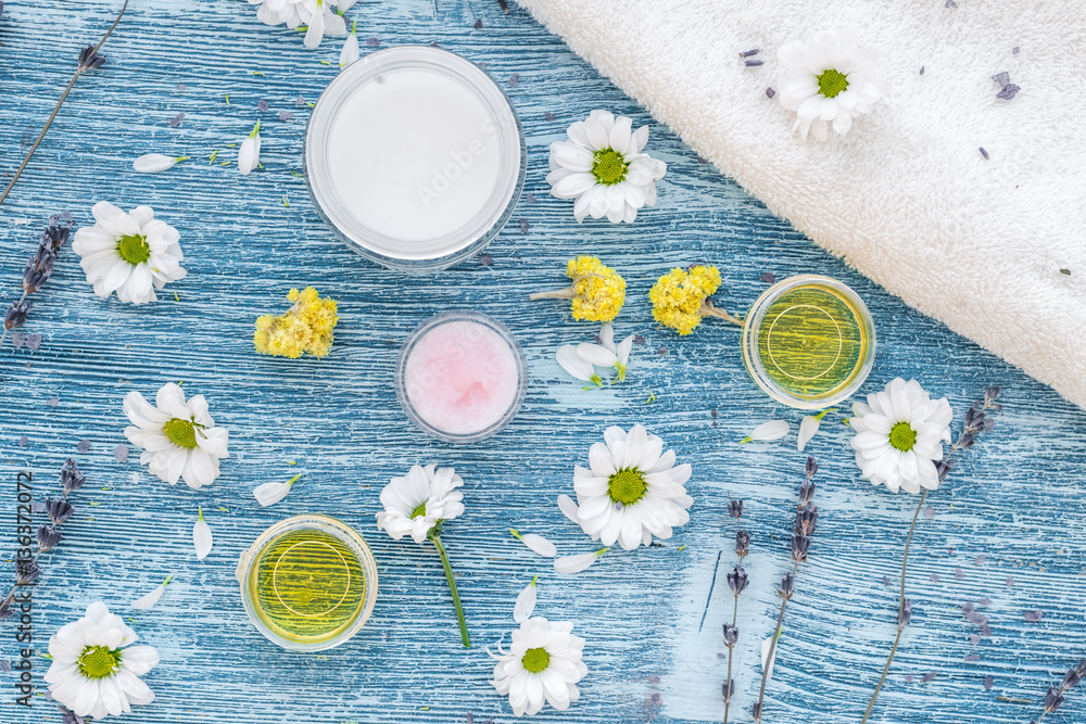 organic cosmetics with camomile on blue background top view