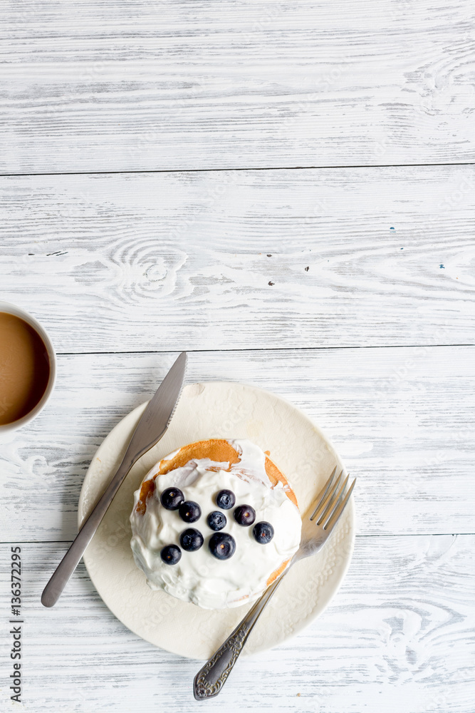 Breakfast concept with flowers on wooden background top view