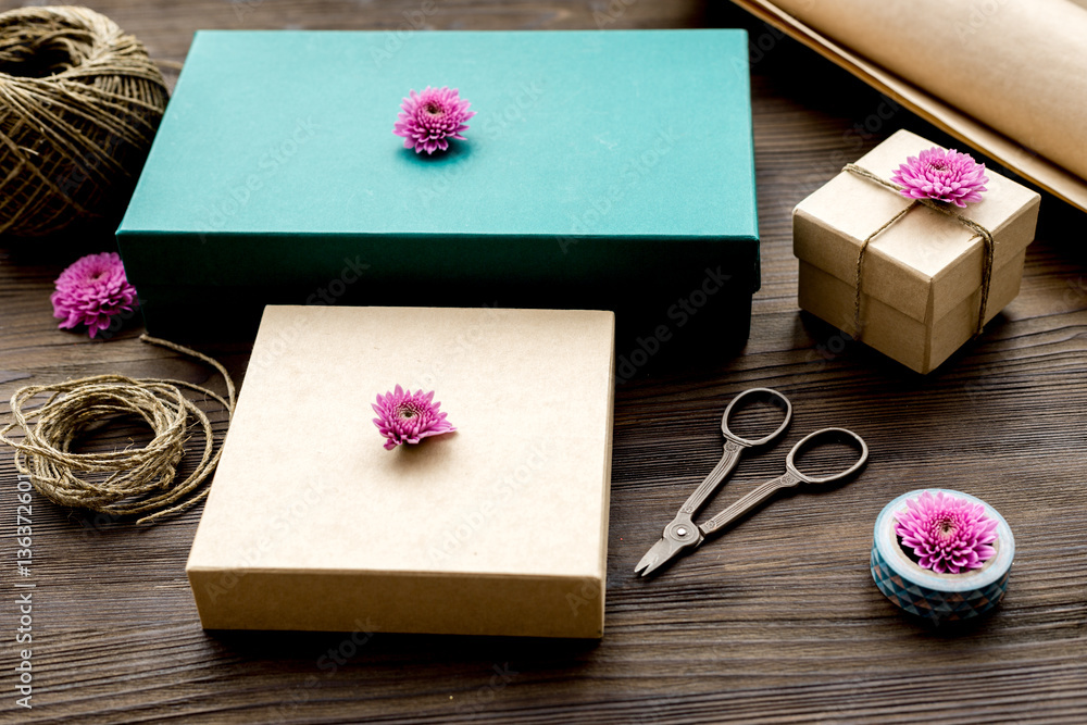 wrapping gifts in box for holiday on wooden background