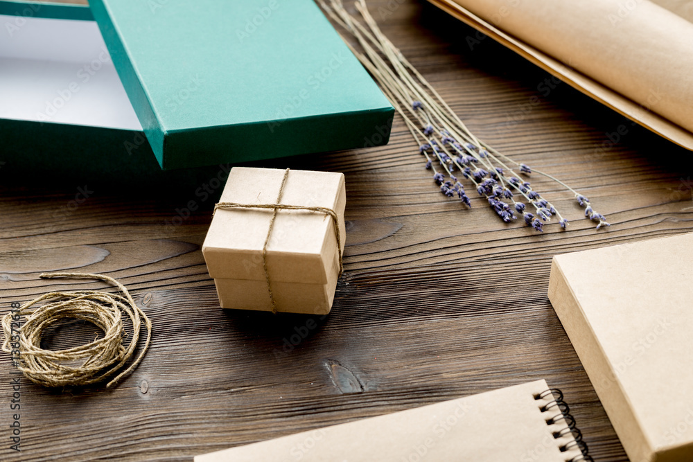 wrapping gifts in box for holiday on wooden background