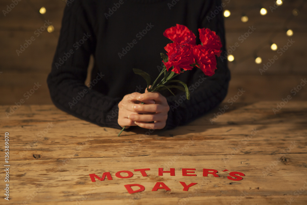 The woman is receiving a red carnation on her mothers day