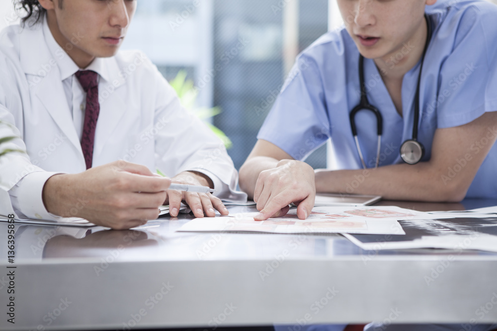 Two doctors are seriously talking in the examination room