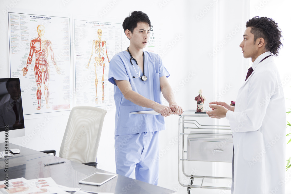 Two doctors are seriously talking in the examination room