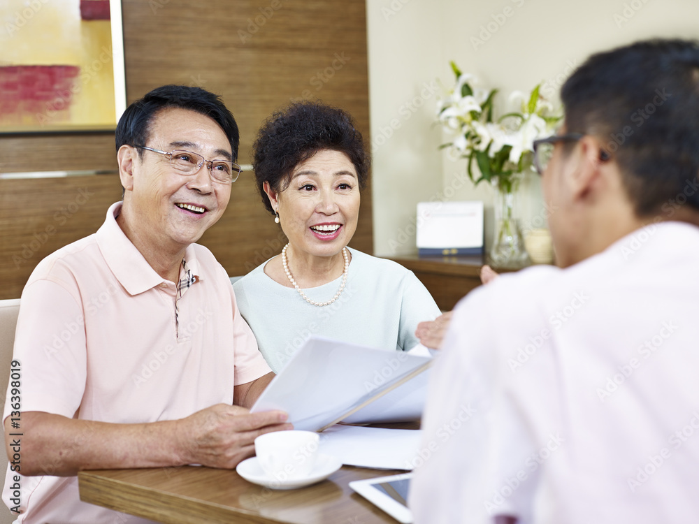 senior asian couple listening to a salesman