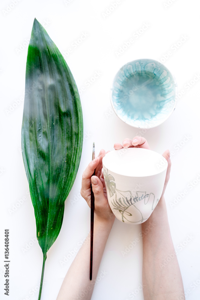 painted ceramic cup on white background top view