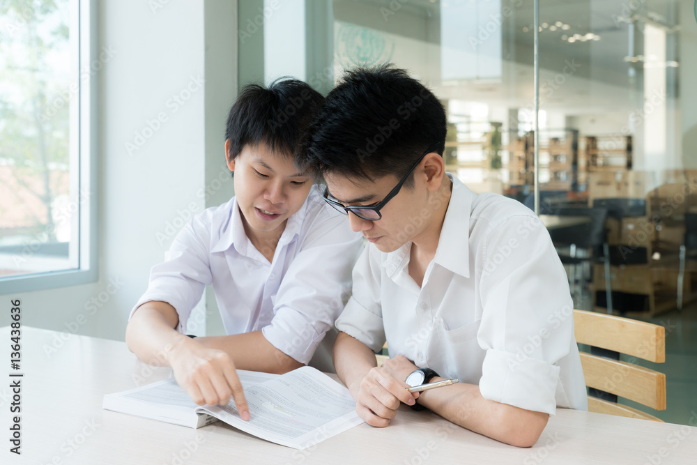 Two Asian students studying together at university...