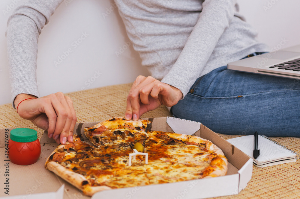 Woman hand scoop up and slice of hot pizza with melting cheese