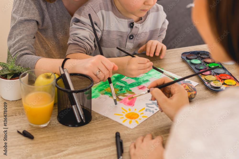 Children with mom painting images with water color and brush