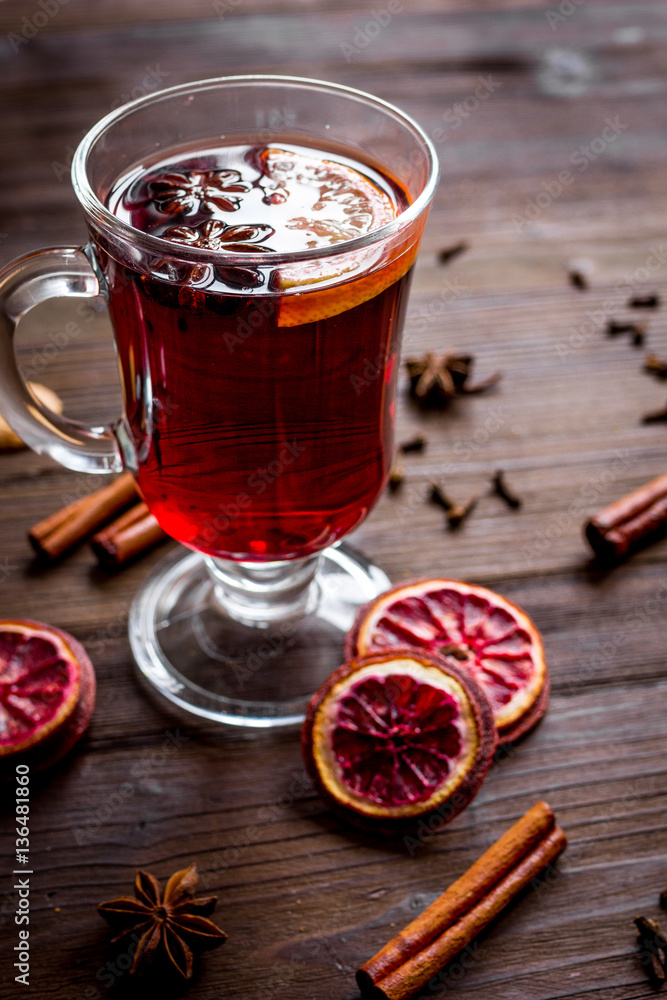 mulled wine with spices in cup on wooden background