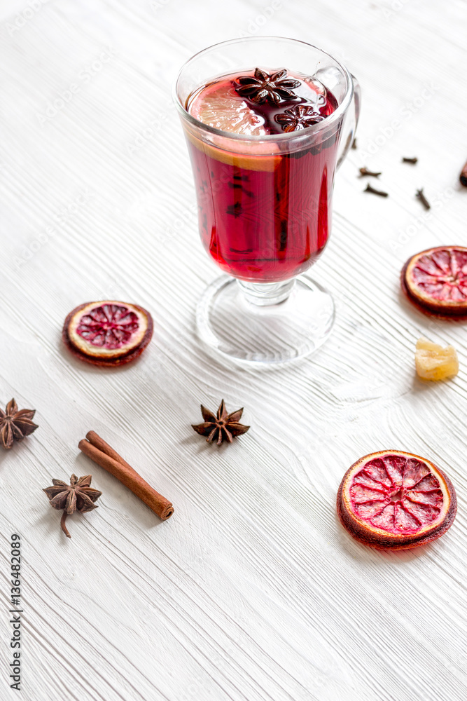 mulled wine with spices in cup on wooden background