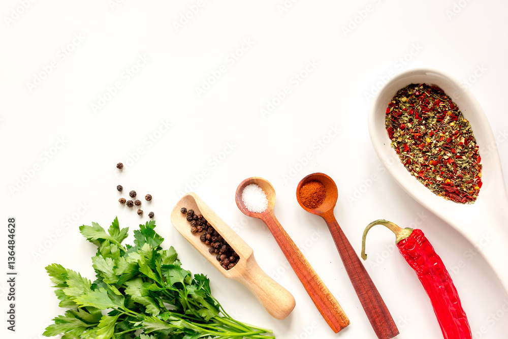 spices in wooden spoon on white background top view