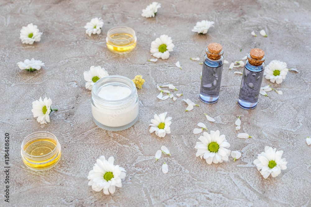 organic cosmetics with camomile on stone background