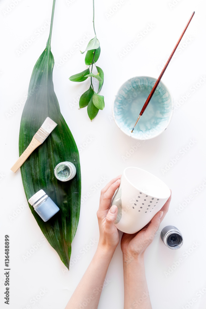 painted ceramic cup on white background top view