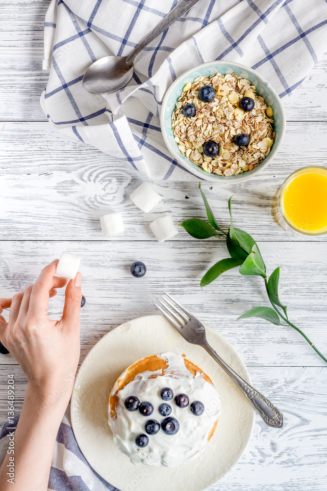 Breakfast concept with flowers on wooden background top view