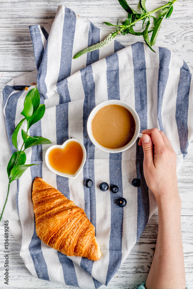 Breakfast concept with flowers on wooden background top view