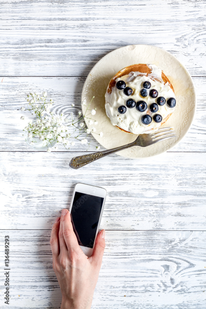 Breakfast concept with flowers on wooden background top view