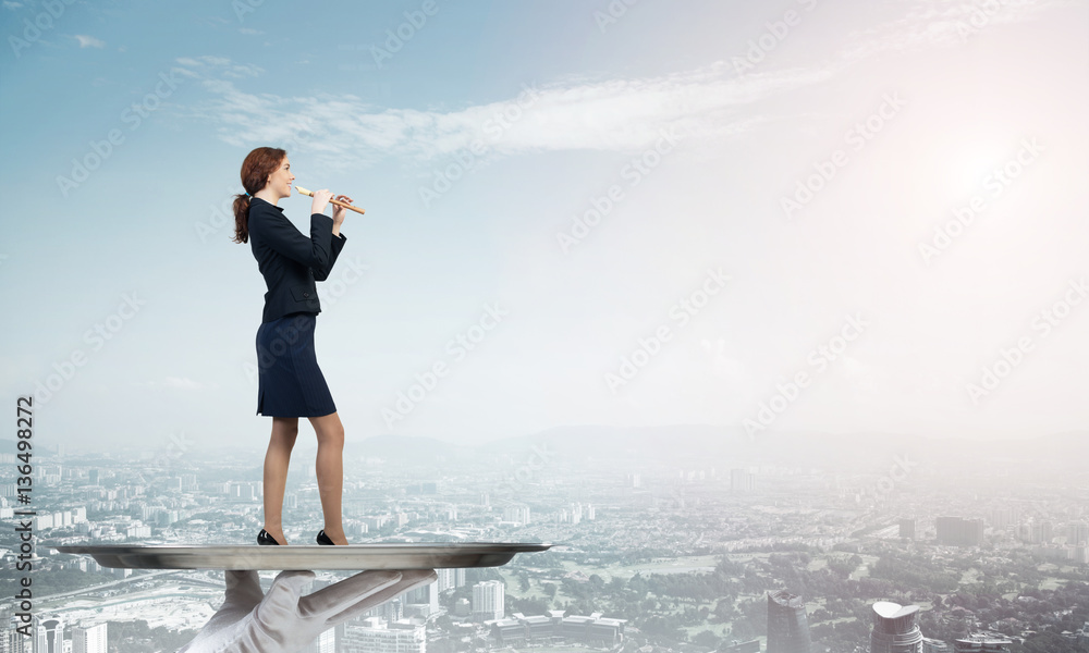 Attractive businesswoman on metal tray playing fife against cityscape background