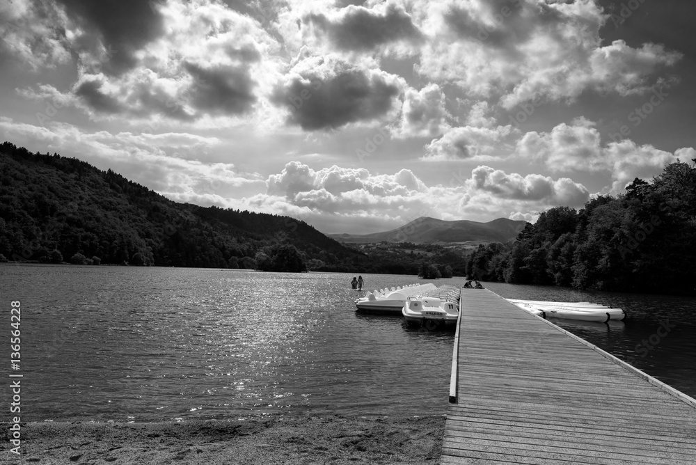 Ciel menacant au Lac Chambon version noir et blanc. Kayaks et pédalos autour du ponton