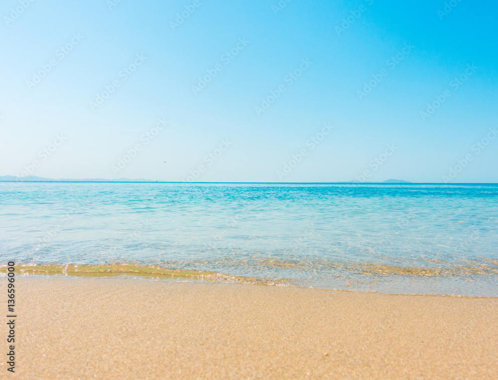 沙滩和热带海洋，沙滩上蓝天海洋的柔和波浪。海景背景