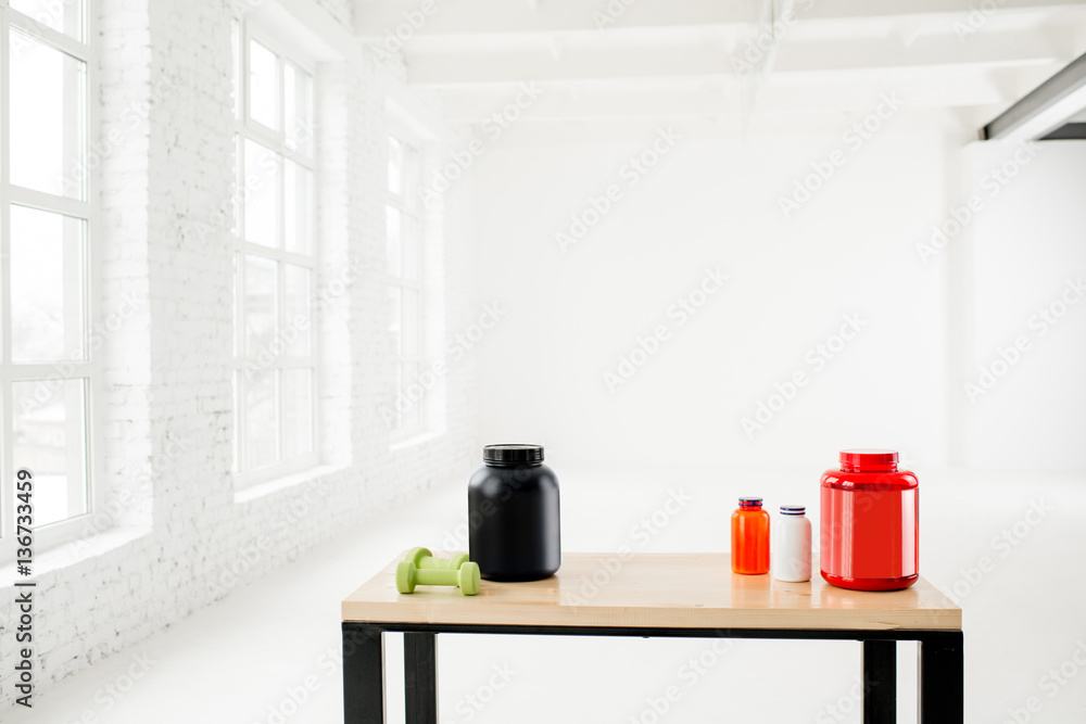 Bottles with sports nutrition and vitamins on the table in the white interior