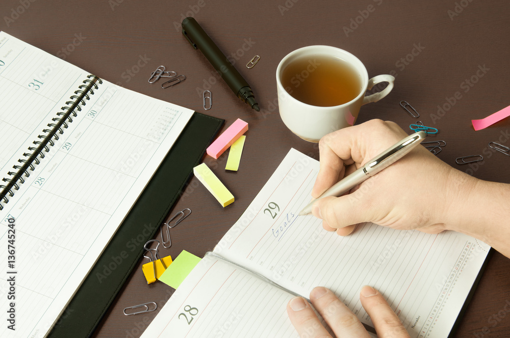 Workplace with organizer, pen, pencil and cup of tea